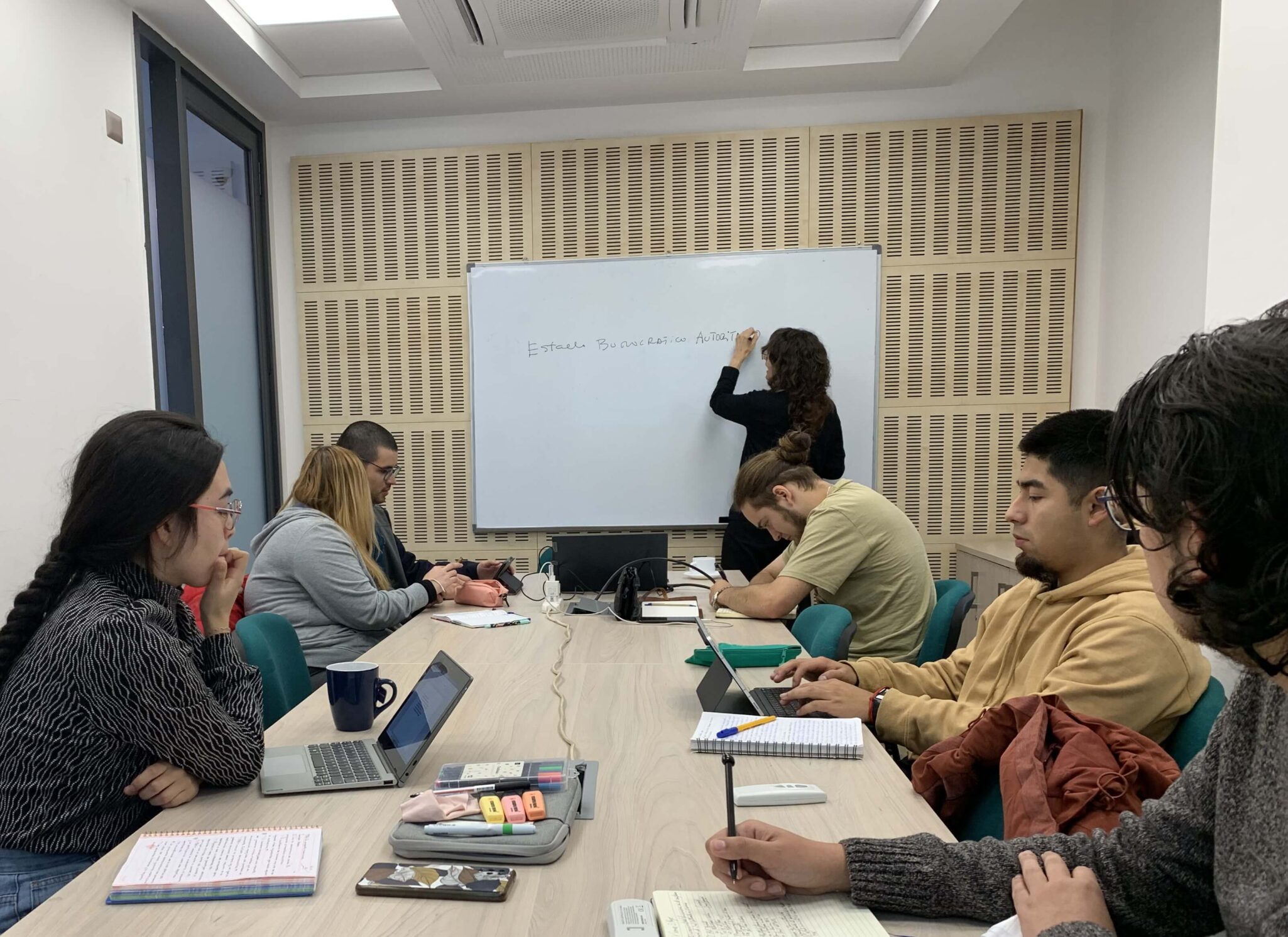 Estudiantes de magíster en sesión de una clase de metodología de la investigación con una profesora invitada extranjera